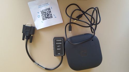 tecla-e device package contents: multiple switch adapter, USB charging cable, getting started guide and the tecla-e device itself