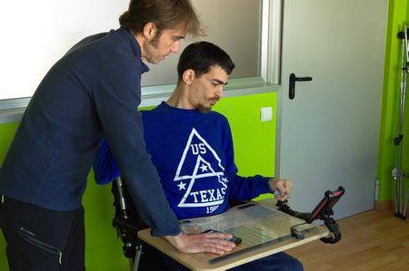 Performing an usabilitity test. Researcher standing and user in wheelchair using a smarthphone